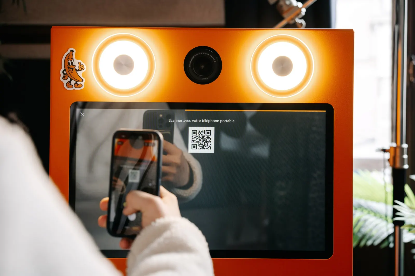 Une invitée scanne le QR code du photobooth pour récupérer ses photos